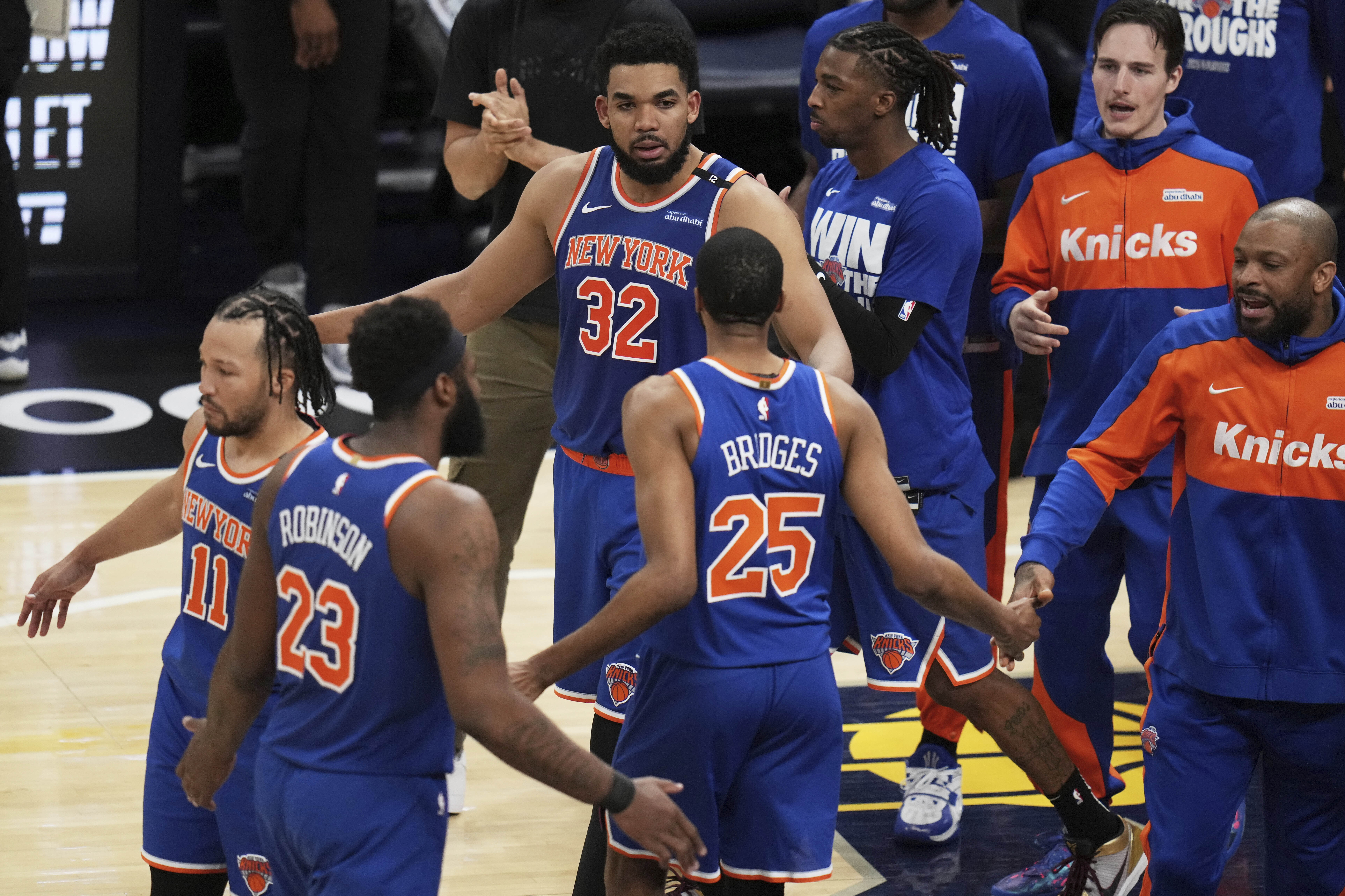 New York Knicks guard Jalen Brunson (11), center Mitchell Robinson (23), center Karl-Anthony Towns (32), forward Mikal Bridges (25) and teammates celebrate after Game 3 of the Eastern Conference finals of the NBA basketball playoffs against the Indiana Pacers Sunday, May 25, 2025, in Indianapolis. 