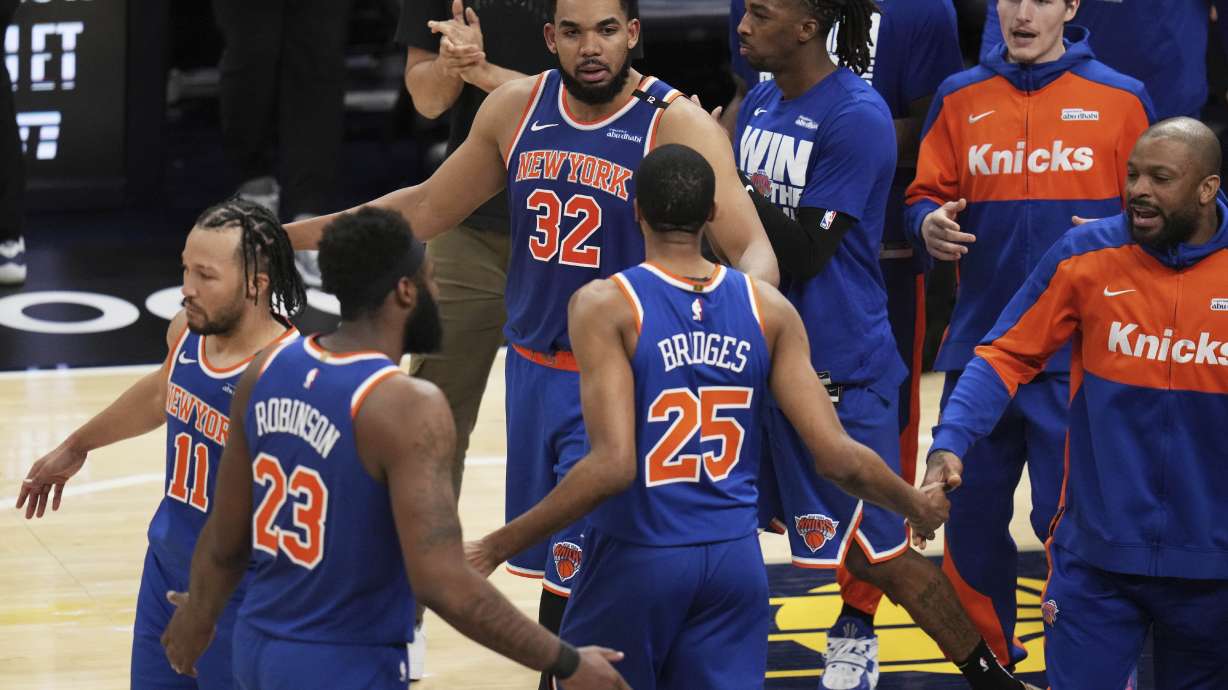 New York Knicks guard Jalen Brunson (11), center Mitchell Robinson (23), center Karl-Anthony Towns (32), forward Mikal Bridges (25) and teammates celebrate after Game 3 of the Eastern Conference finals of the NBA basketball playoffs against the Indiana Pacers Sunday, May 25, 2025, in Indianapolis.