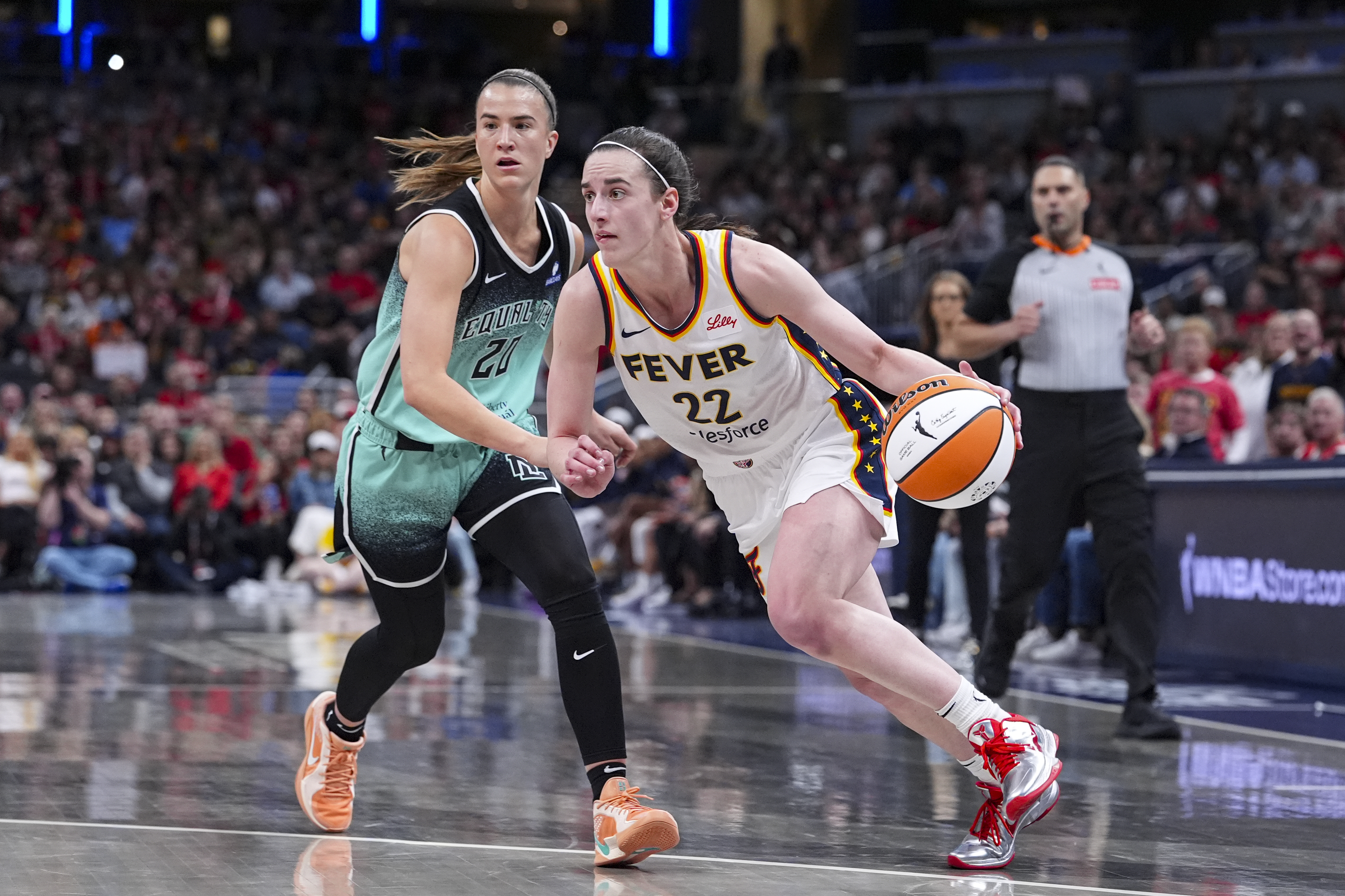 Indiana Fever guard Caitlin Clark (22) drives on New York Liberty guard Sabrina Ionescu (20) in the second half of a WNBA basketball game in Indianapolis, Saturday, May 24, 2025. 