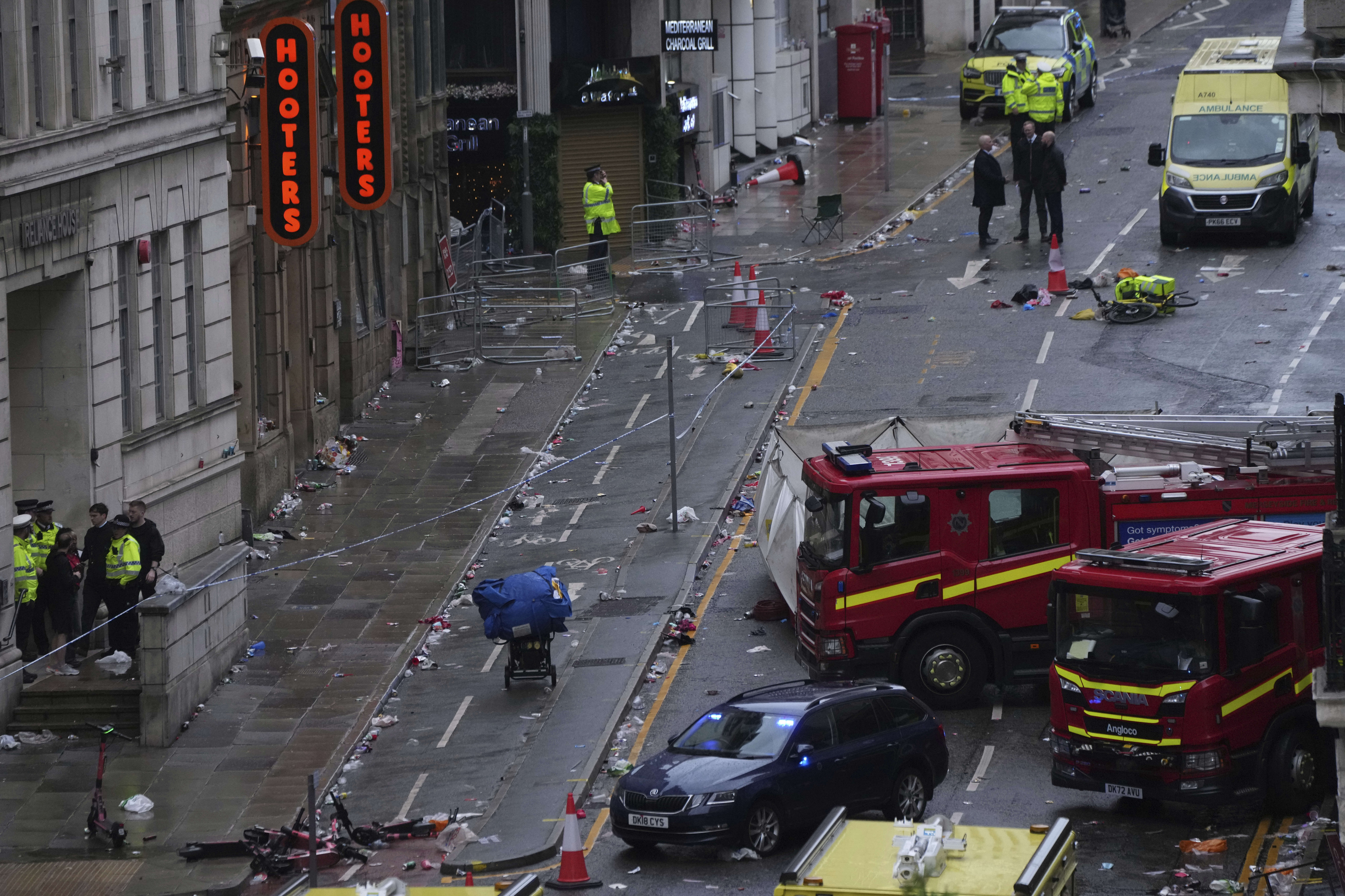 Fans leave as Police and emergency personnel deal with an incident after a car collided with pedestrians near the Liver Building during the Premier League winners parade in Liverpool, England, Monday, May 26, 2025.