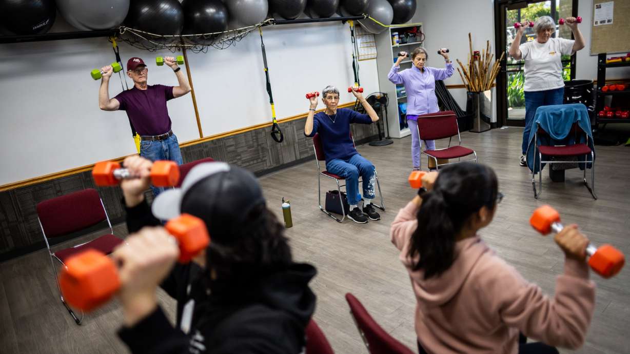 Kinesiology seniors at the University of Utah Brayden Kellogg, front left, and Nanci Delacruz, front right, instruct an overall fitness class targeted toward senior adults for their capstone class at the Murray City Senior Recreation Center on Tuesday.