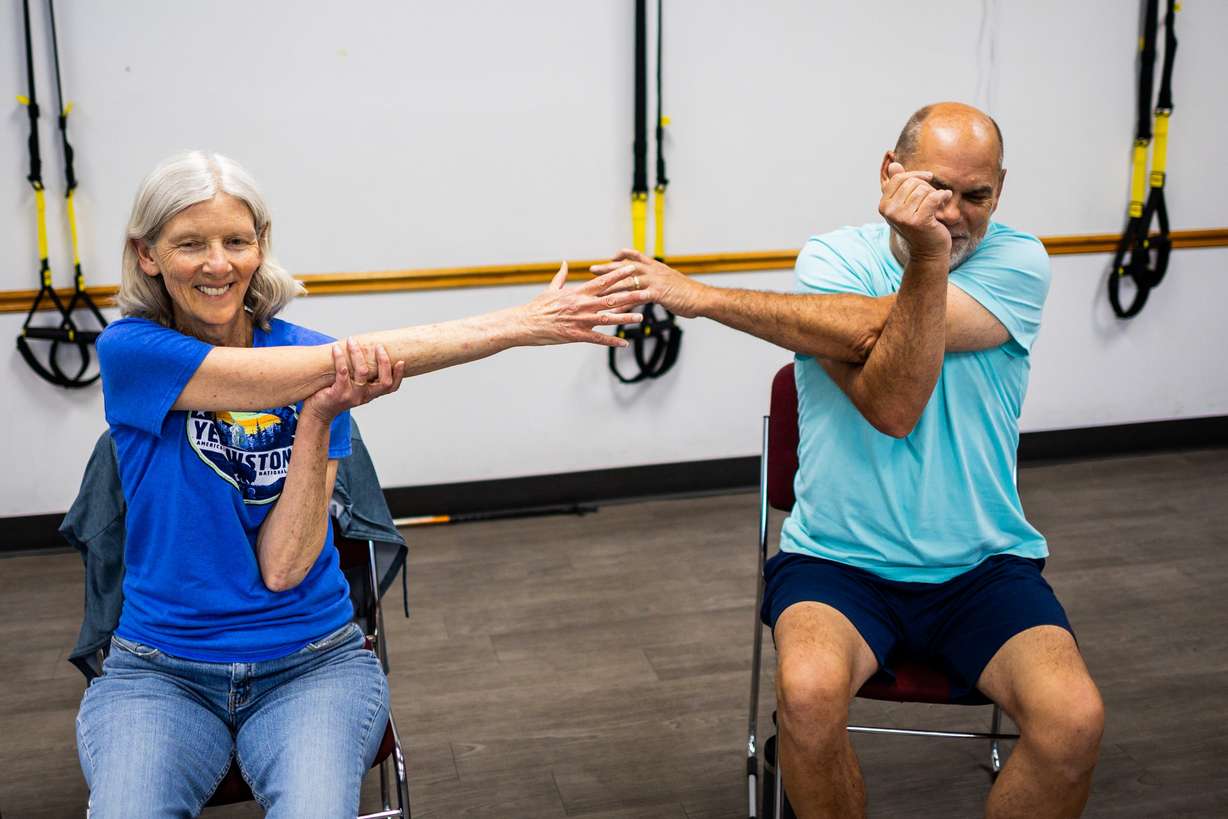 Heidi Brinker, left, and husband, Kent Brinker, right, stretch after participating in an overall fitness class targeted toward senior adults at the Murray City Senior Recreation Center on Tuesday.
