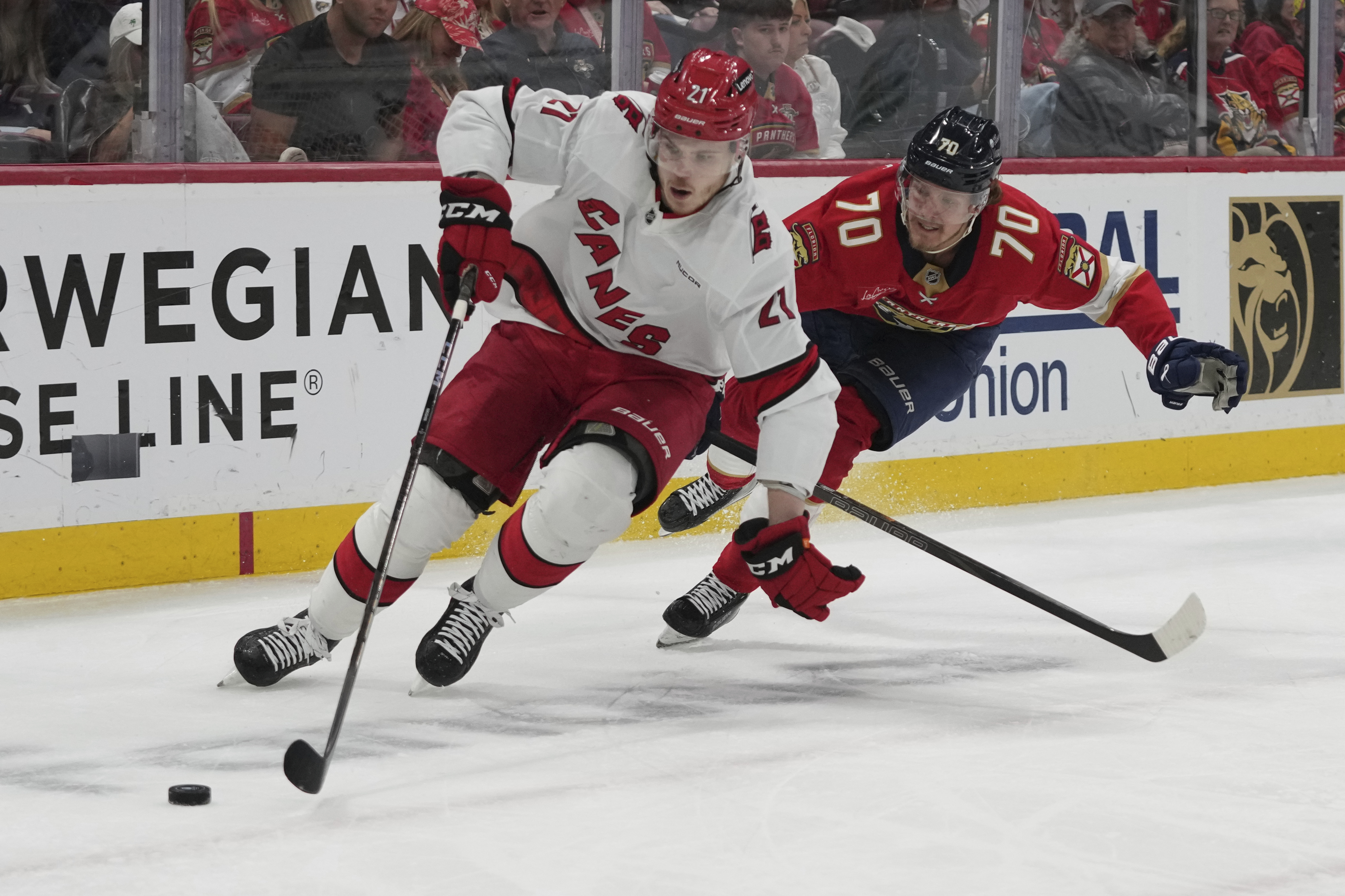 Carolina Hurricanes defenseman Alexander Nikishin (21) and Florida Panthers center Jesper Boqvist (70) go after the puck during the second period in Game 4 of the NHL hockey Stanley Cup Eastern Conference finals, Monday, May 26, 2025, in Sunrise, Fla. 