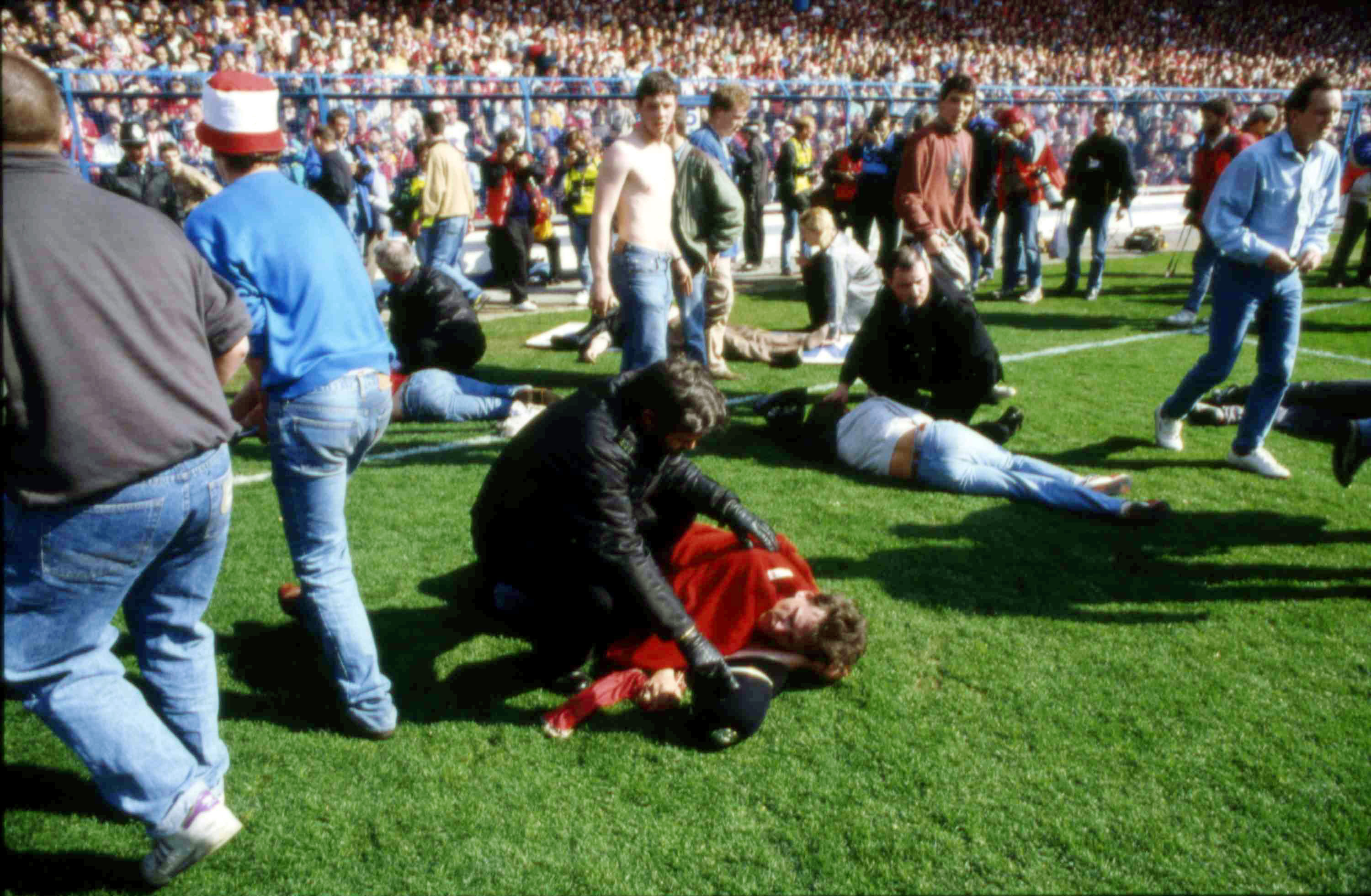 FILE - Stewards and supporters tend and care for wounded supporters on the field at Hillsborough Stadium, in Sheffield, England, April 15, 1989. 