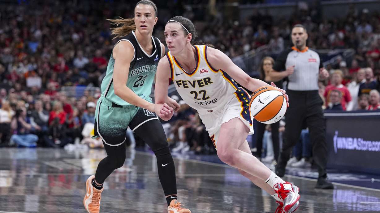 Indiana Fever guard Caitlin Clark (22) drives on New York Liberty guard Sabrina Ionescu (20) in the second half of a WNBA basketball game in Indianapolis, Saturday, May 24, 2025.