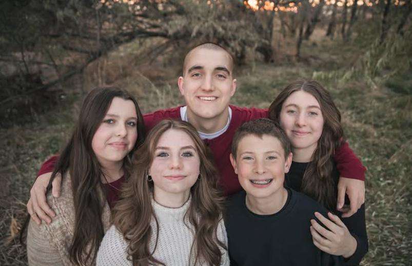 Roman Groves, 19, poses with his three sisters and one brother.