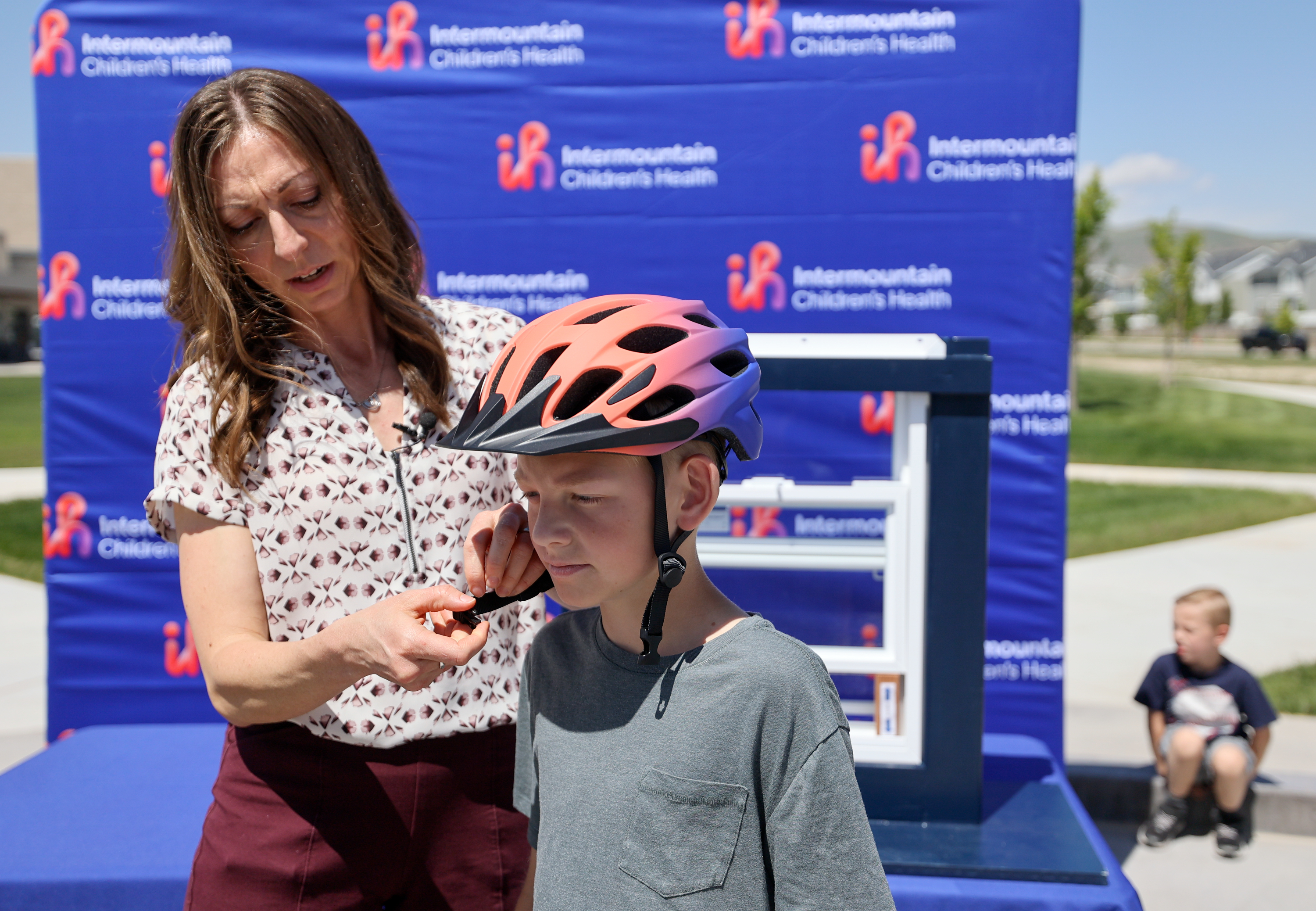 Michelle Cameron and Anthony Crapo demonstrate how to correctly wear a helmet outside Intermountain Health’s Primary Children’s Hospital Larry H. and Gail Miller Family Campus in Lehi on May 23.