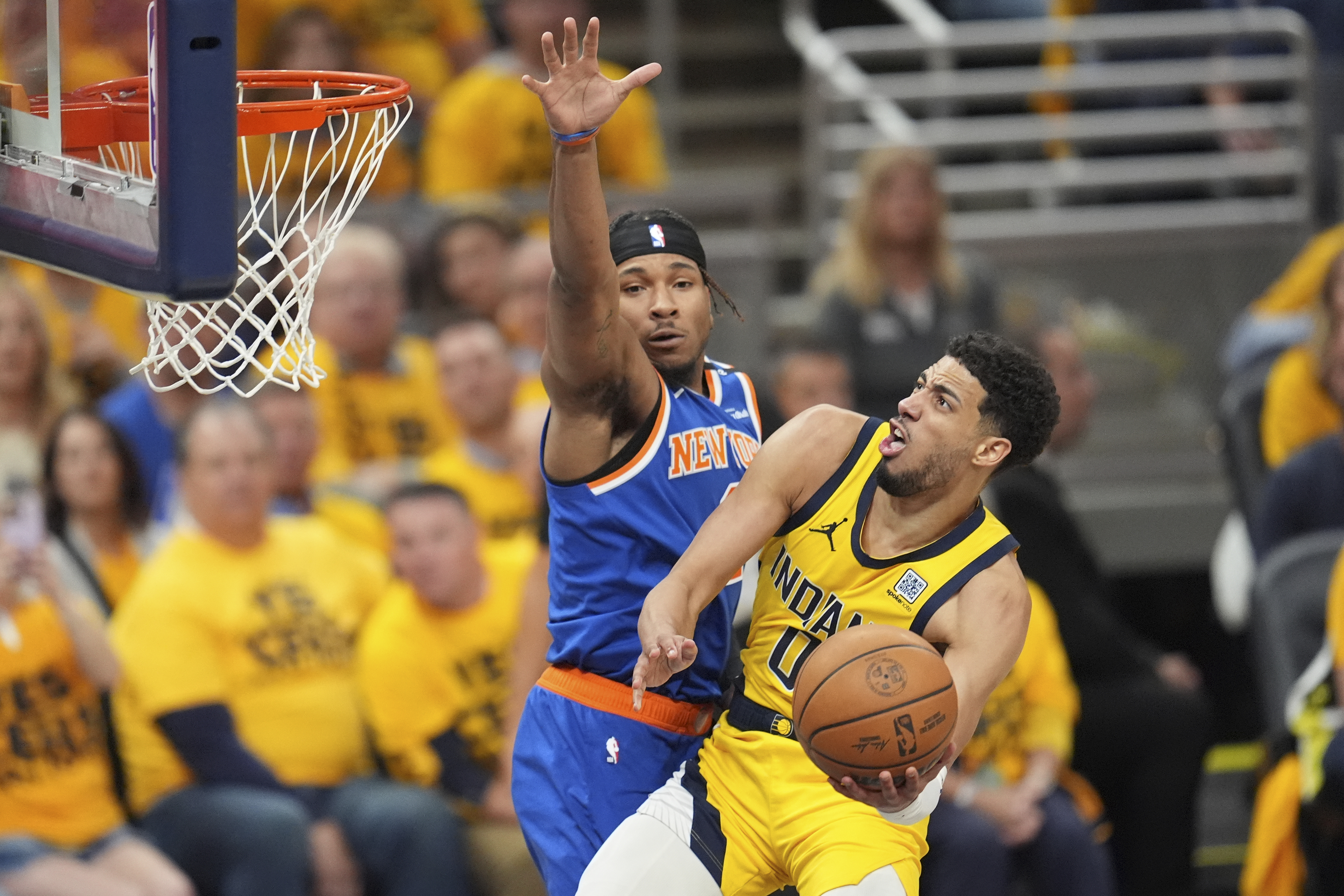 Indiana Pacers guard Tyrese Haliburton (0) shoots the ball past New York Knicks guard Miles McBride, left, during the second half of Game 4 of the Eastern Conference finals of the NBA basketball playoffs in Indianapolis, Tuesday, May 27, 2025.