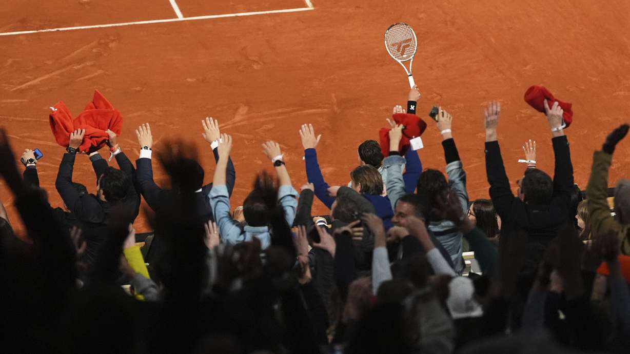 FILE - France's Arthur Rinderknech participates in the wave with fans during a first-round match against Italy's Jannik Sinner in the French Tennis Open at the Roland-Garros stadium in Paris, Monday, May 26, 2025.