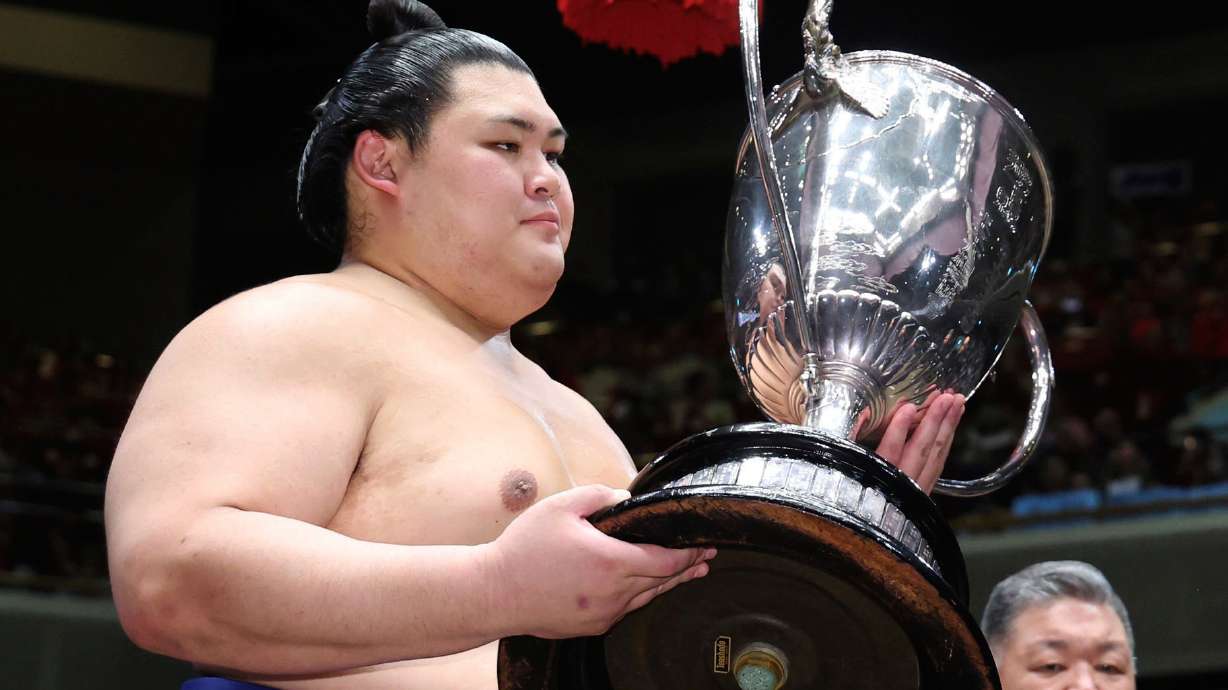 Onosato receives the trophy after winning in a sumo wrestling tournament at Ryogoku Kokugikan arena in Tokyo, Sunday, May 25, 2025.