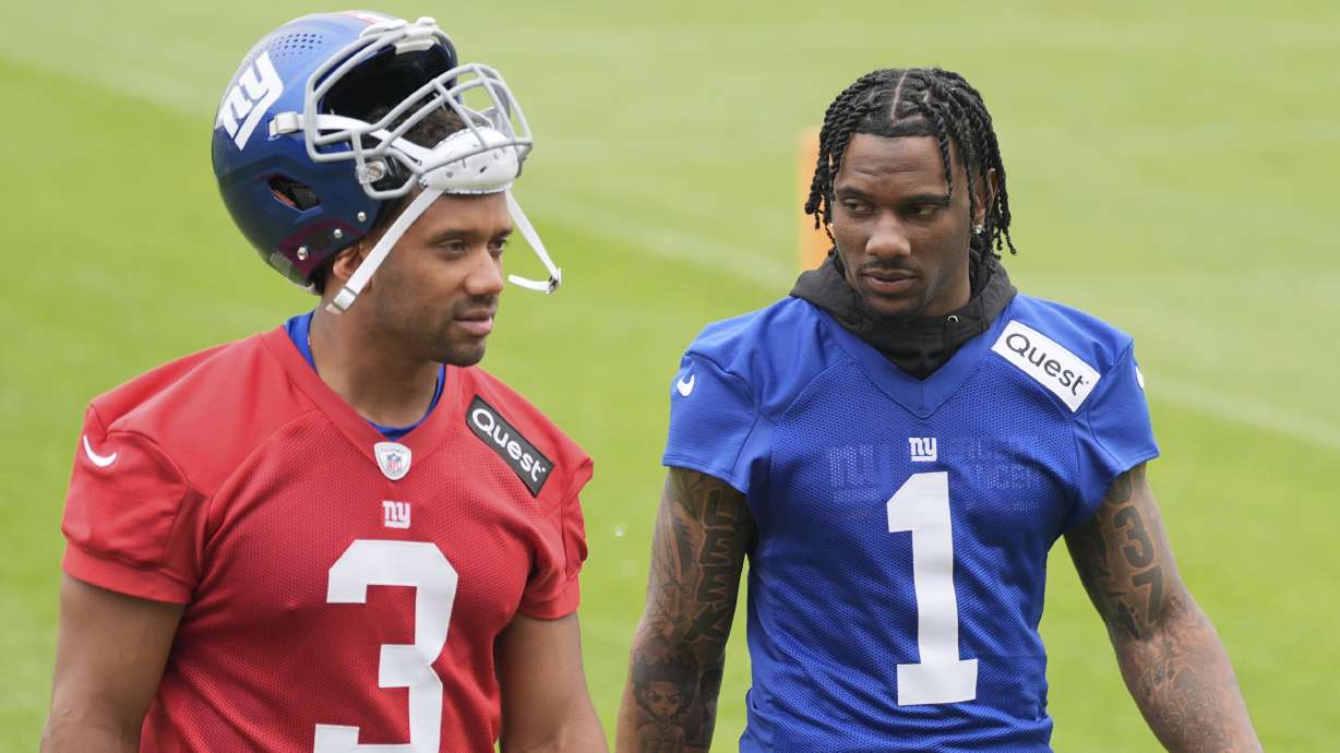 New York Giants' Malik Nabers, right, talks with quarterback Russell Wilson as they walk off the field after NFL football practice in East Rutherford, N.J., Wednesday, May 28, 2025.