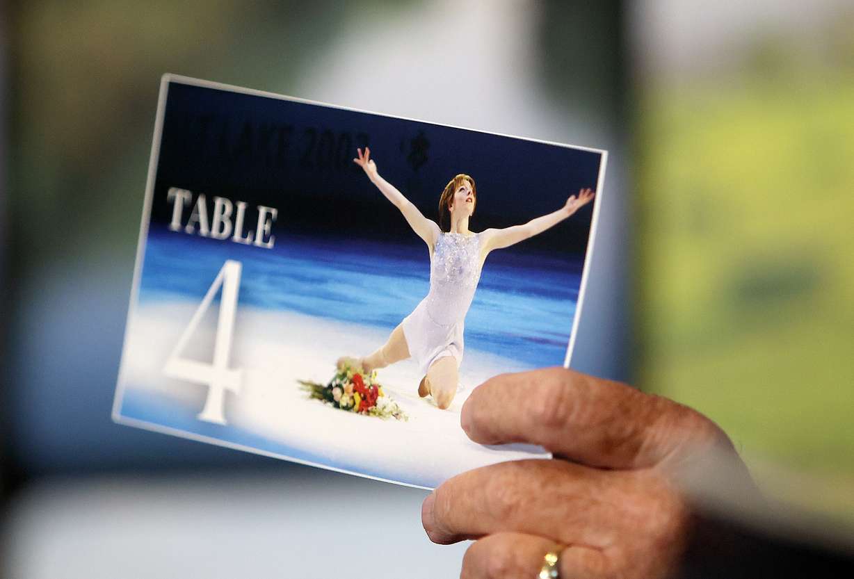 Former Gov. Mike Leavitt holds a photo of Sarah Hughes, who won the women's figure skating gold medal at the 2002 Winter Olympics, while discussing the 2034 Olympic and Paralympic Games at the Spring Breakfast with Envision Utah at the Rice-Eccles Stadium in Salt Lake City on Wednesday.