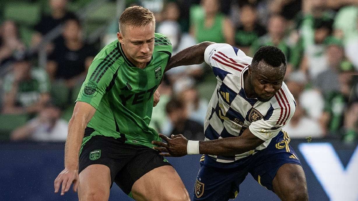 William Agada, right, struggles against an Austin defender on the road.