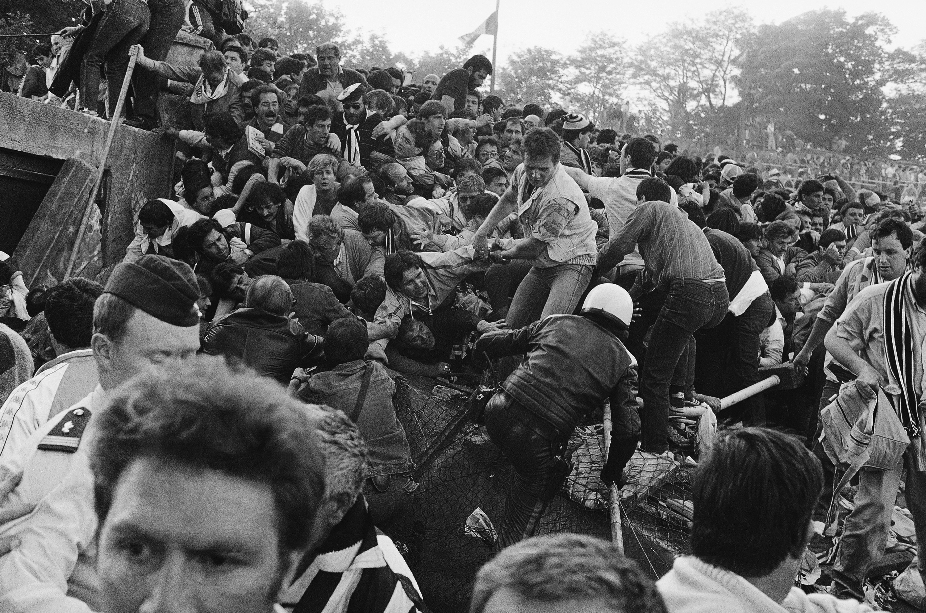 FILE - A crowd of soccer fans in the Brussels Heysel stadium, falls down in a heavy group over the broken fence just prior to the European Champion's Cup Final between Liverpool and Juventus of Turin, in Brussels, Belgium, May 29, 1985. 