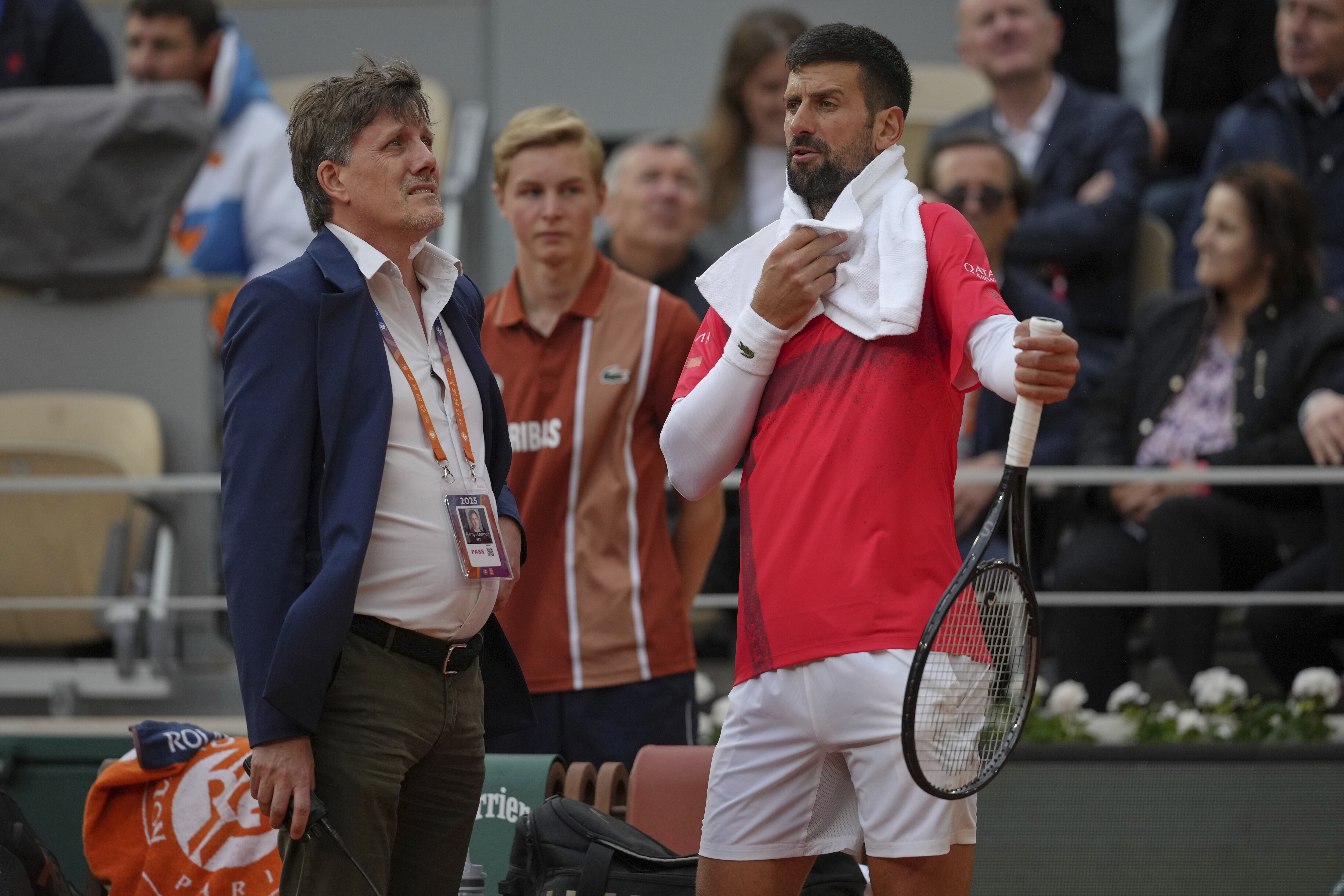 Serbia's Novak Djokovic talks with officials as he plays Mackenzie McDonald of the U.S. during their first round match of the French Tennis Open, at the Roland-Garros stadium, in Paris, Tuesday, May 27, 2025.