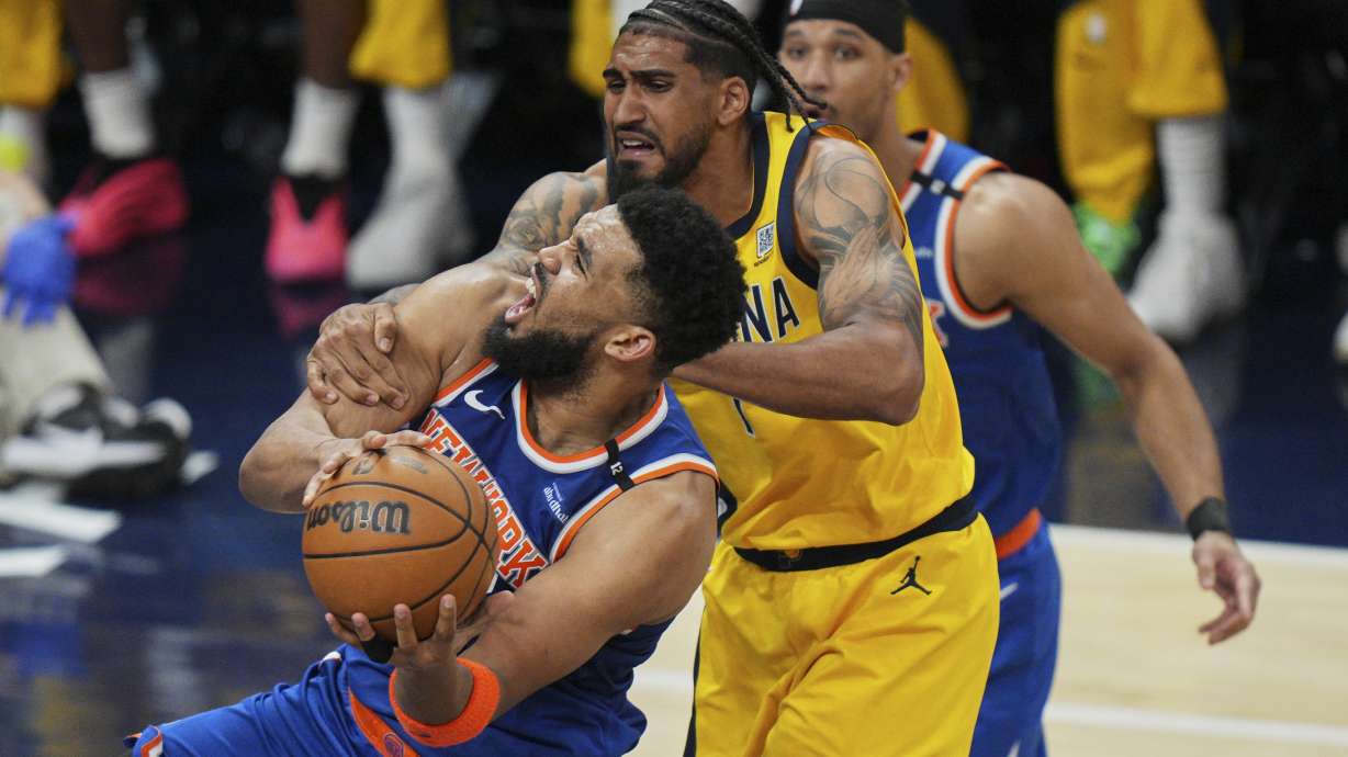 New York Knicks center Karl-Anthony Towns, left, shoots the ball past Indiana Pacers forward Obi Toppin, right, during the second half of Game 4 of the Eastern Conference finals of the NBA basketball playoffs in Indianapolis, Tuesday, May 27, 2025.