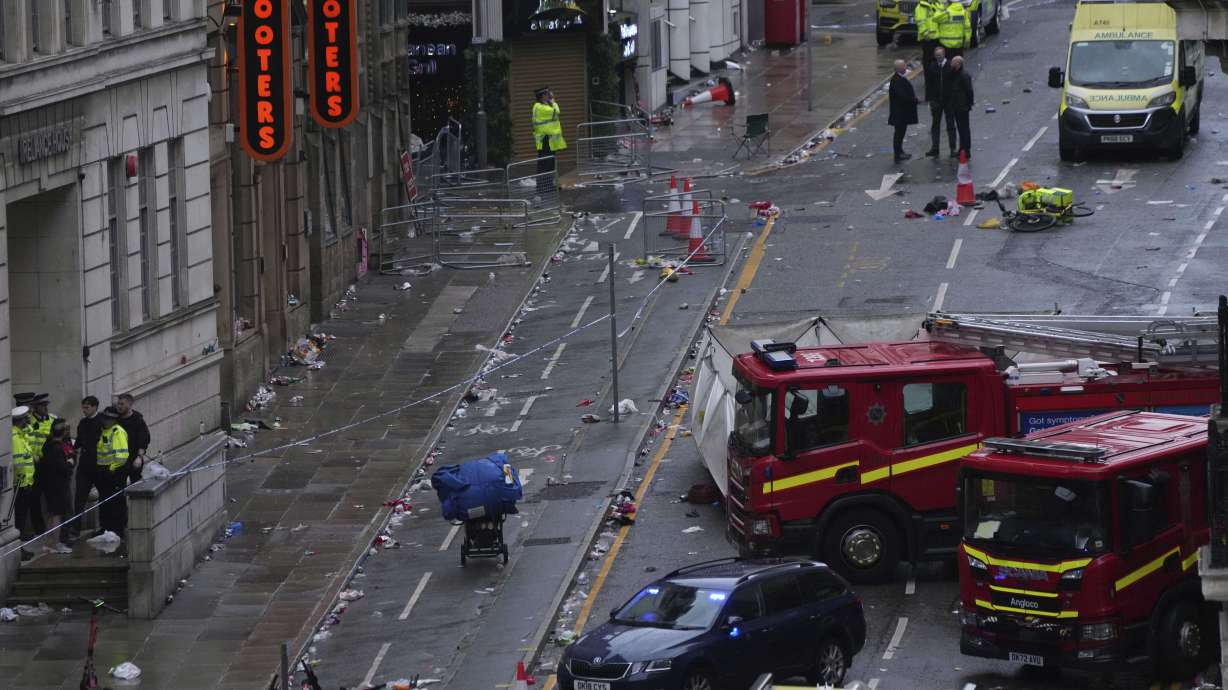 Fans leave as Police and emergency personnel deal with an incident after a car collided with pedestrians near the Liver Building during the Premier League winners parade in Liverpool, England, Monday, May 26, 2025.