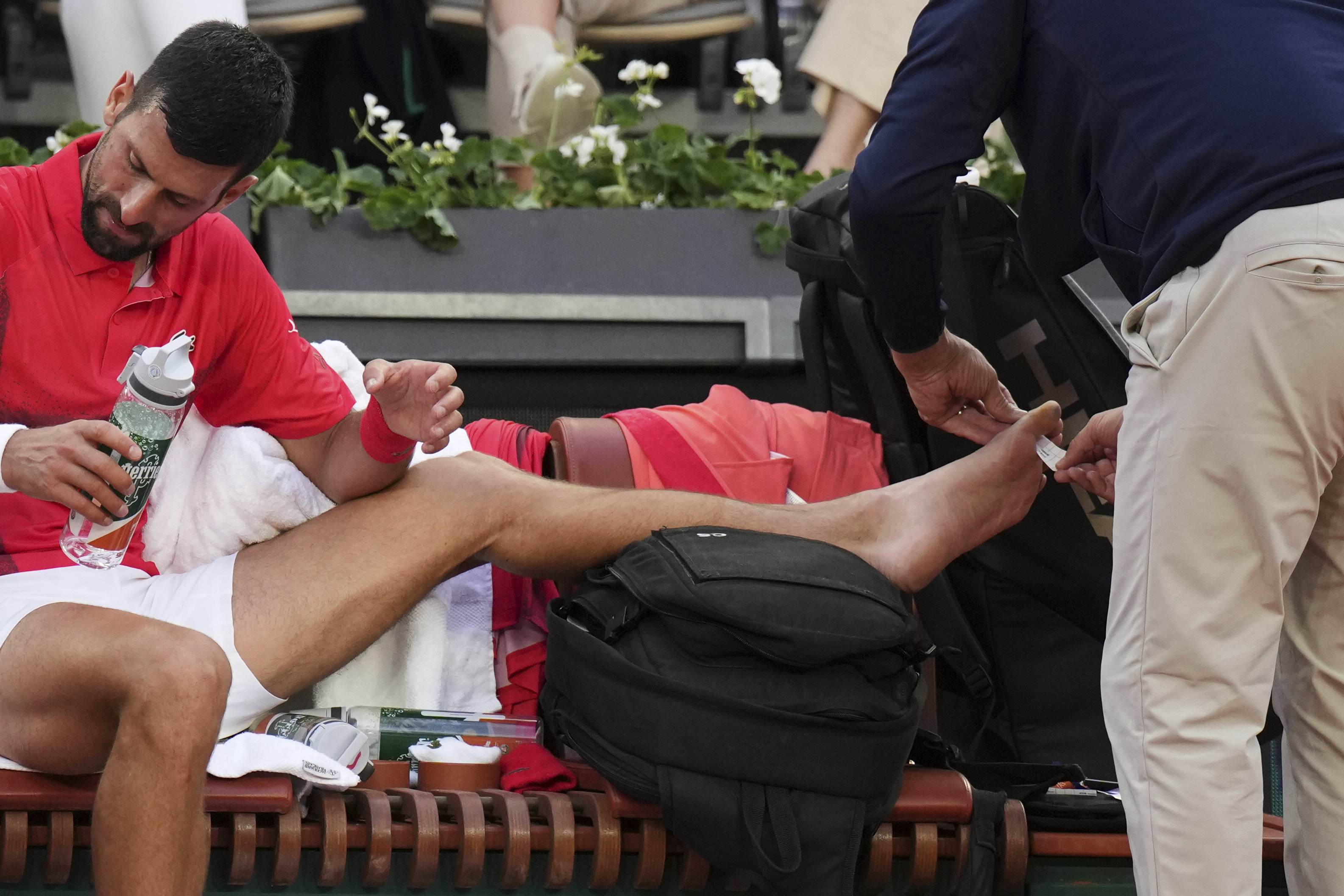 Serbia's Novak Djokovic receives medical assistance during his second round match of the French Tennis Open against France's Corentin Moutet, at the Roland-Garros stadium, in Paris, Thursday, May 29, 2025. 