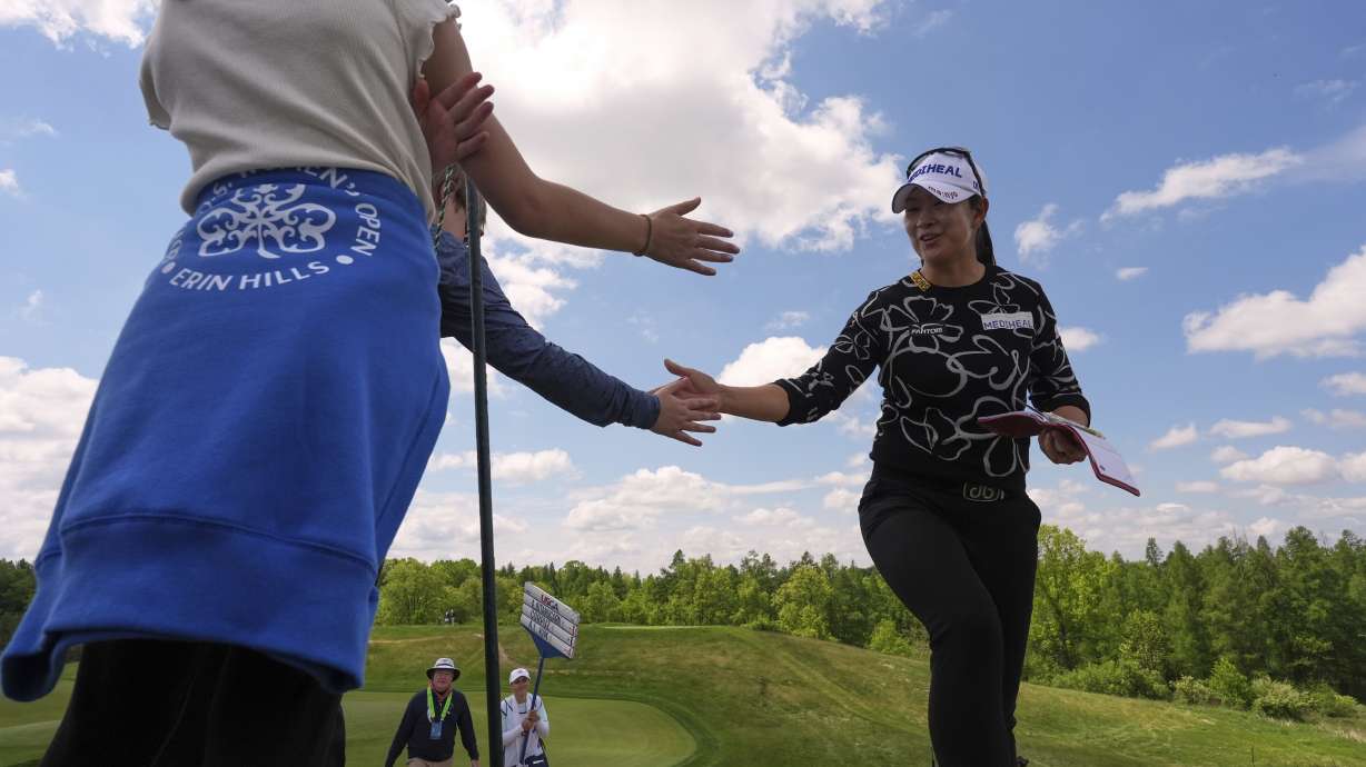 A Lim Kim, of South Korea, greets fans walking to the third tee during the first round of the U.S. Women's Open golf tournament at Erin Hills Thursday, May 29, 2025, in Erin, Wis.