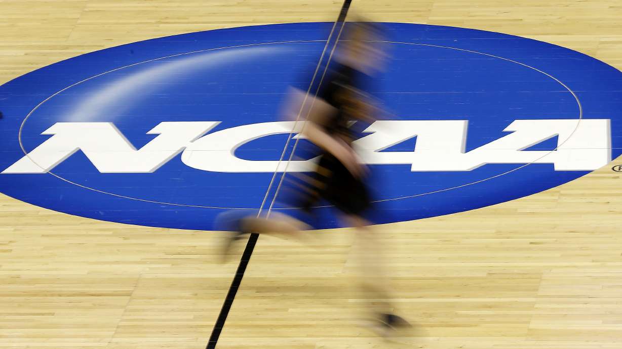 In this photo taken with a slow shutter speed, Wichita State's Ron Baker runs during practice for the NCAA college basketball tournament, March 20, 2014, in St. Louis.