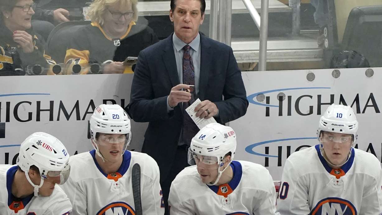 FILE - New York Islanders head coach Lane Lambert, center top, stands behind the bench during the first period of an NHL hockey game against the Pittsburgh Penguins, Sunday, Dec. 31, 2023, in Pittsburgh.