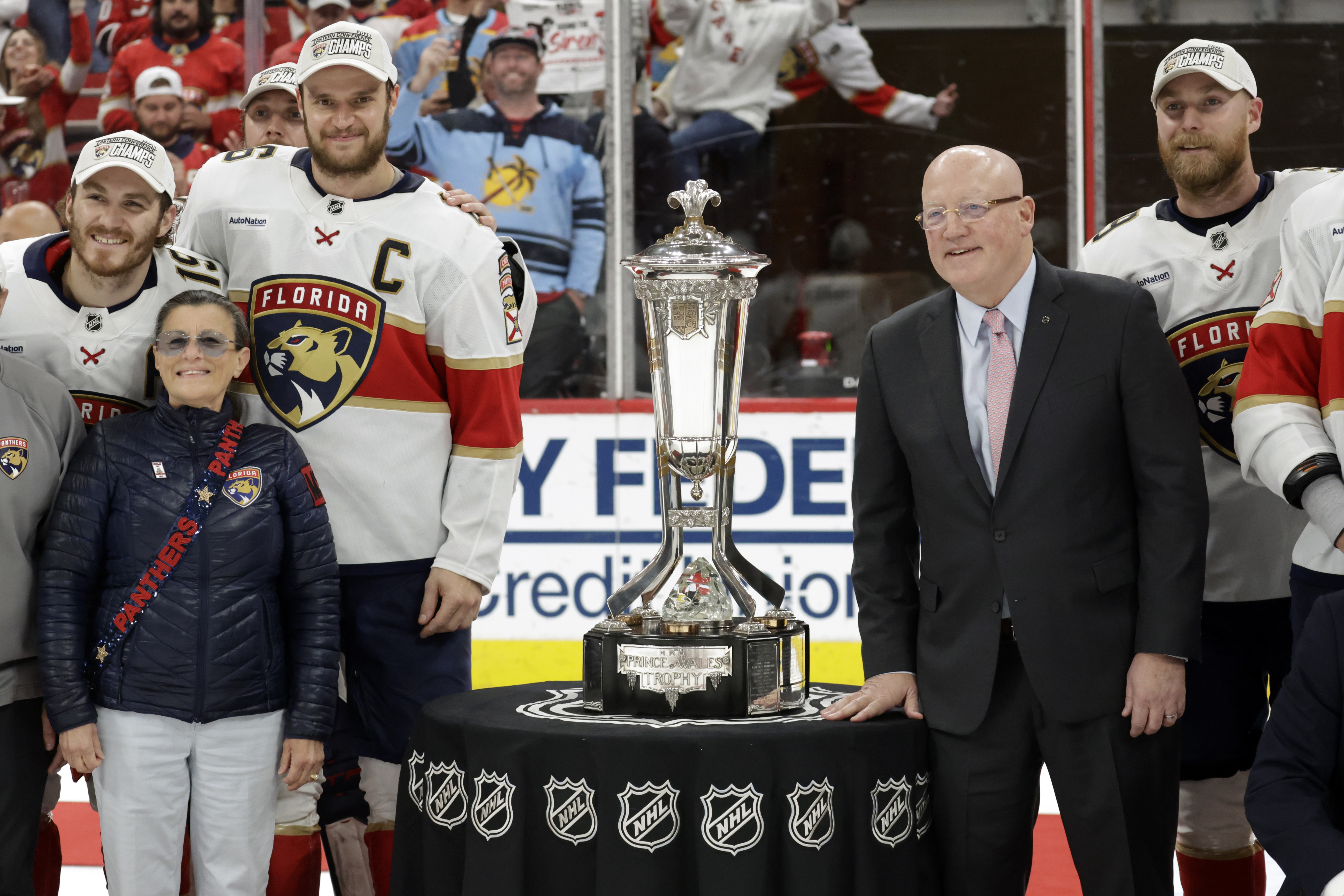 Florida Panthers center Aleksander Barkov (C) and NHL Deputy Commissioner Bill Daly, right, pose with the Prince of Wales trophy at the end of Game 5 of the NHL hockey Stanley Cup Eastern Conference finals Wednesday, May 28, 2025, in Raleigh, N.C. They advance to the Stanley Cup finals. 