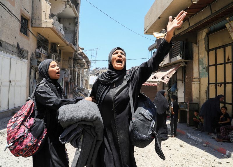 A Palestinian woman reacts in the aftermath of an Israeli strike on a house, in Gaza City, Friday.