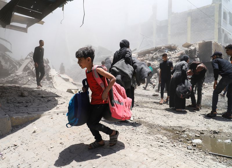 Palestinians evacuate in the aftermath of an Israeli strike on a house, in Gaza City, Friday.
