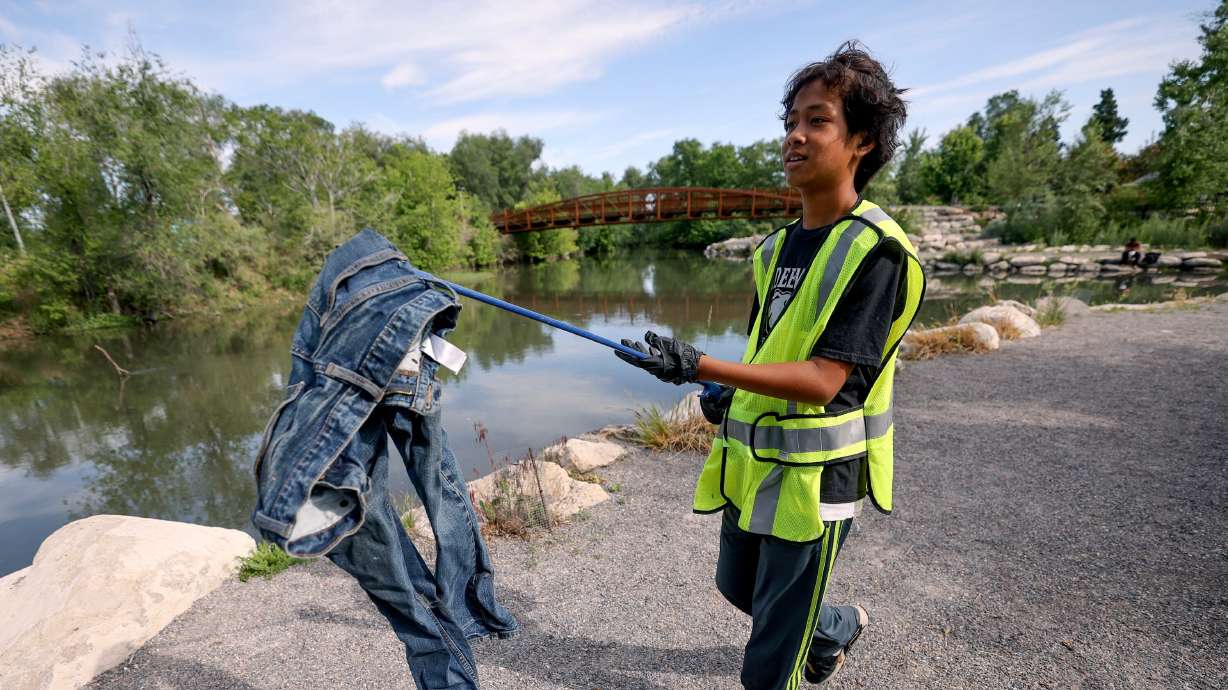 Seventh grader Jesse Hum and other students from Redeemer Lutheran Church and School, in collaboration with Seven Canyons Trust, help clean up Three Creeks Confluence Park in Salt Lake City on Thursday.