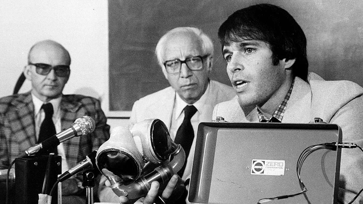 Drs. Don Olsen, left, and Willem Kolff listen as Dr. Robert Jarvik explains his artificial heart on Aug. 13, 1980. Jarvki died Monday at age 79.