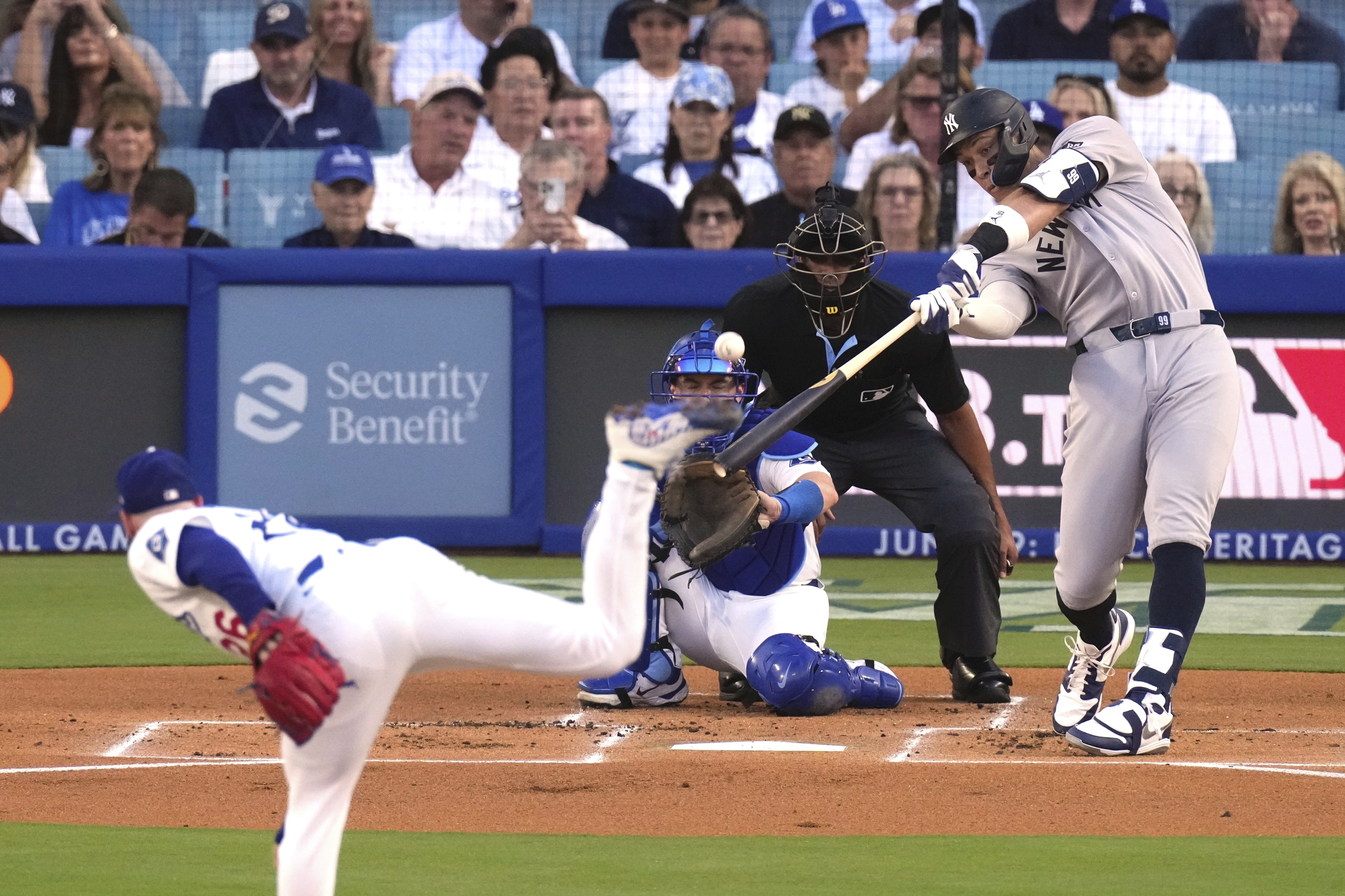 New York Yankees' Aaron Judge, right, hits a solo home run as Los Angeles Dodgers starting pitcher Tony Gonsolin, left, and catcher Will Smith watch during the first inning of a baseball game Friday, May 30, 2025, in Los Angeles.