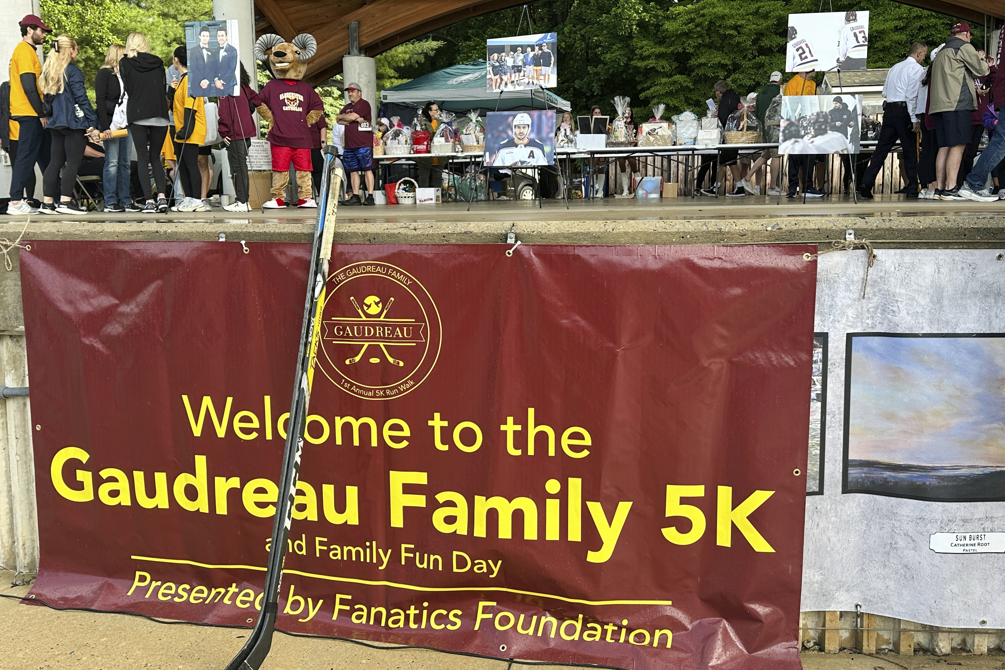 Hockey sticks from various vigils for hockey players Johnny and Matthew Gaudreau, who were fatally struck by a motorist while riding bicycles, rest against a sign at the inaugural Gaudreau Family 5K Walk, Run and Family Day, Saturday, May 31, 2025, in Sewell, N.J. 