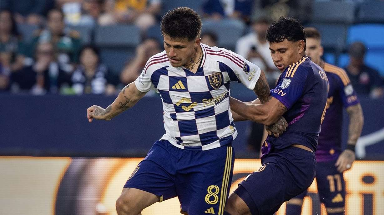 Diego Luna fends off an LA Galaxy defender on the road.