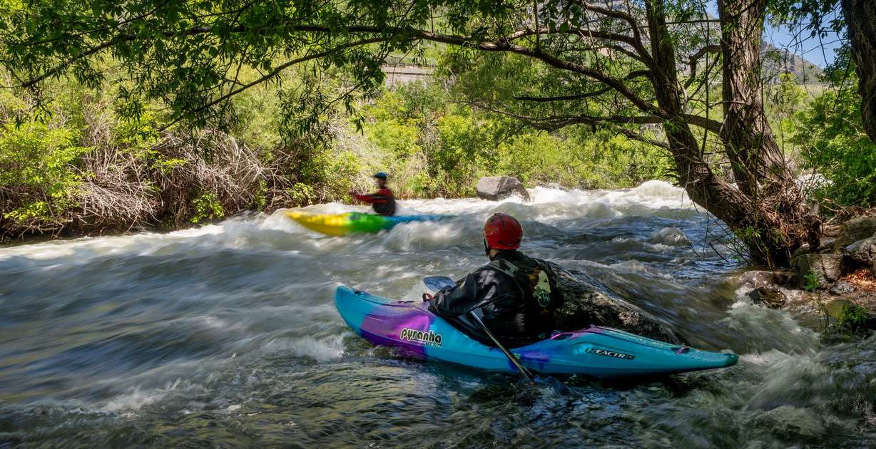 A safety boat watches as competitors compete in the Provo River Race, a whitewater kayak competition in Provo Canyon on Saturday.