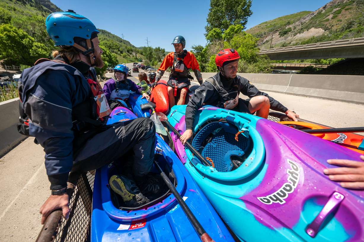 Competitors ride on a trailer back to the start after making runs as they compete in the Provo River Race, a whitewater kayak competition in Provo Canyon on Saturday.