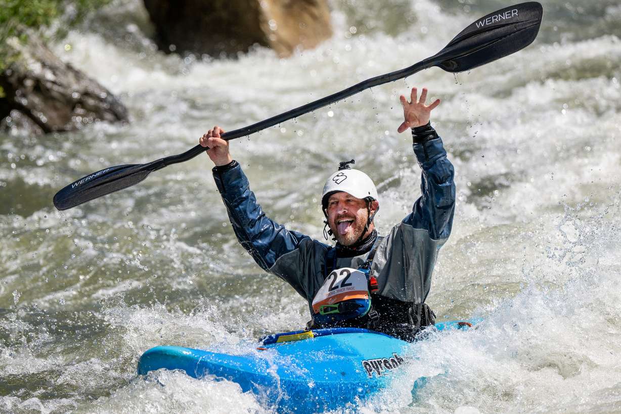 Chad Phillips reacts to people watching from the shore as he works his way down the course as competitors compete in the Provo River Race, a whitewater kayak competition in Provo Canyon on Saturday.