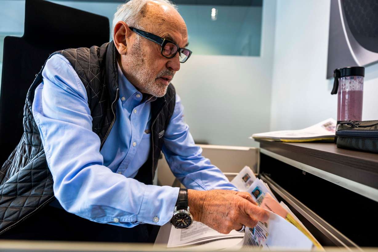 Z.A. Konarski, a 77-year-old native of Poland, who has been selling Porsches for 40-plus years, flips through stacks of documents chronicling his sales for the last 40 years, in his office at the Porsche dealership in Salt Lake City on May 14. When asked how many cars he has sold, Konarski is quick to clarify: He doesn’t sell cars — he sells Porsches, a brand he has been passionate about since his youth in communist Poland.