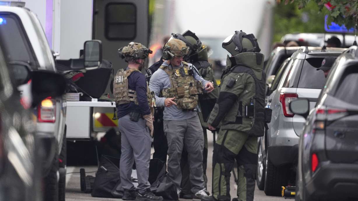 Law enforcement officials dress to investigate after an attack on the Peark Street Mall Sunday in Boulder, Colo. Eight people were injured when a man yelled "Free Palestine" and threw incendiary devices into a crowd.