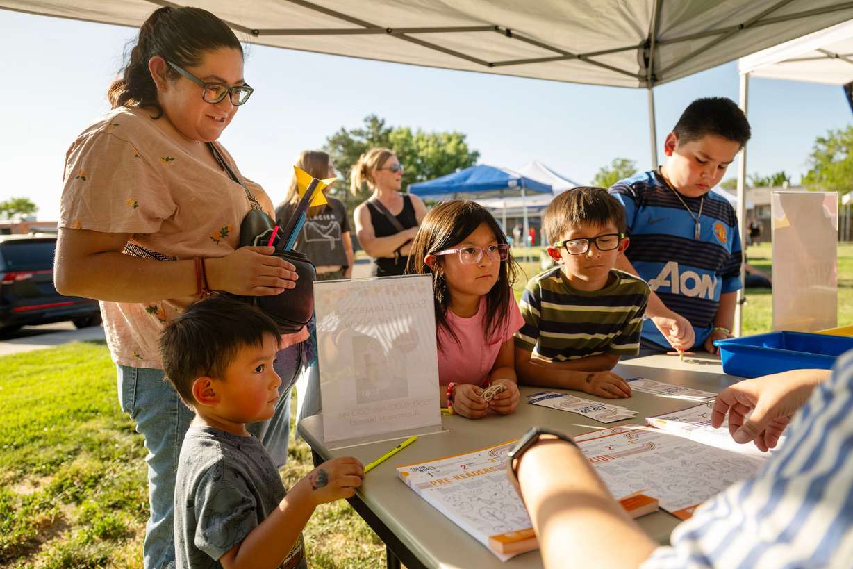 Tania Vargas and her kids Damian Perez, Anya Perez, Andress Perez, and Gian Facio listen as Christina Walsh, Taylorsville Library branch manager, gives reading program instructions as Taylorsville Library holds its summer reading kickoff party on May 30.
