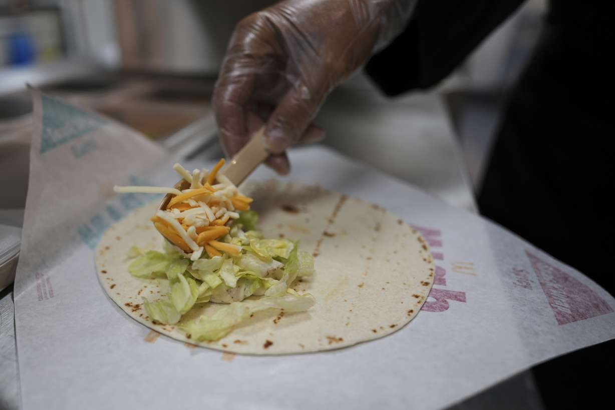 Charles L. Krumsiek, a McDonald's chef, puts cheese on a tortilla to make a Snack Wrap at McDonald's Headquarters in Chicago, Thursday. McDonald's is bringing back the Snack Wrap to U.S. markets.