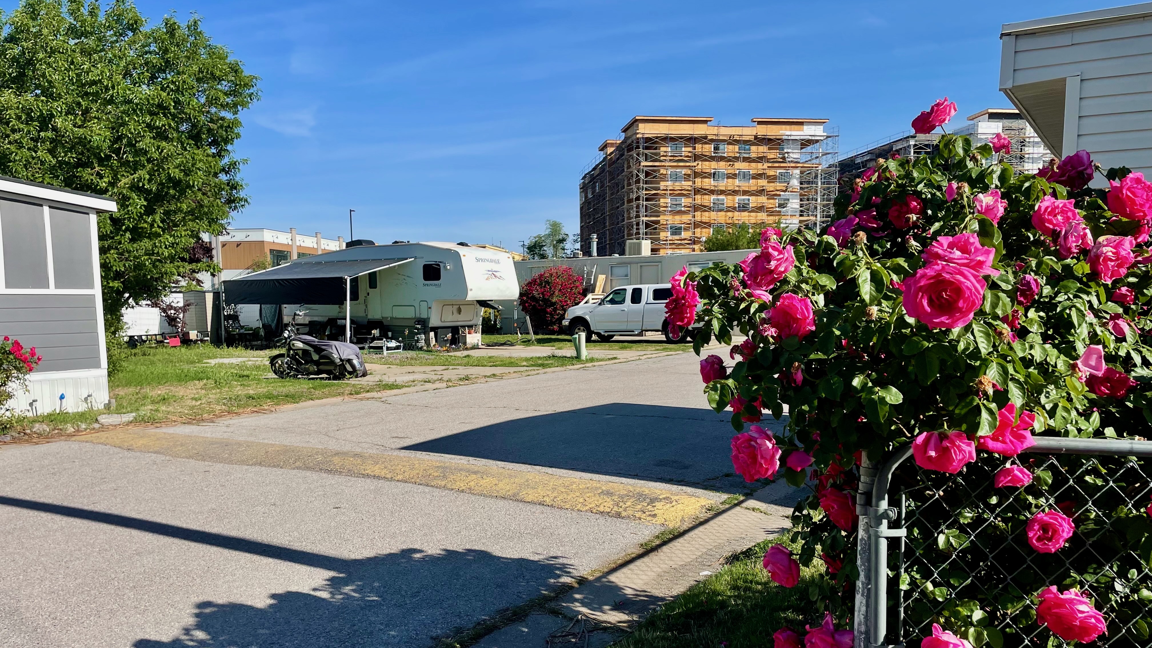 A new apartment building takes shape in the distance next to the Cedarwood Mobile Home Park, just east of the Layton FrontRunner station, on May 28. Layton officials have approved a development plan for the area around the city's station.