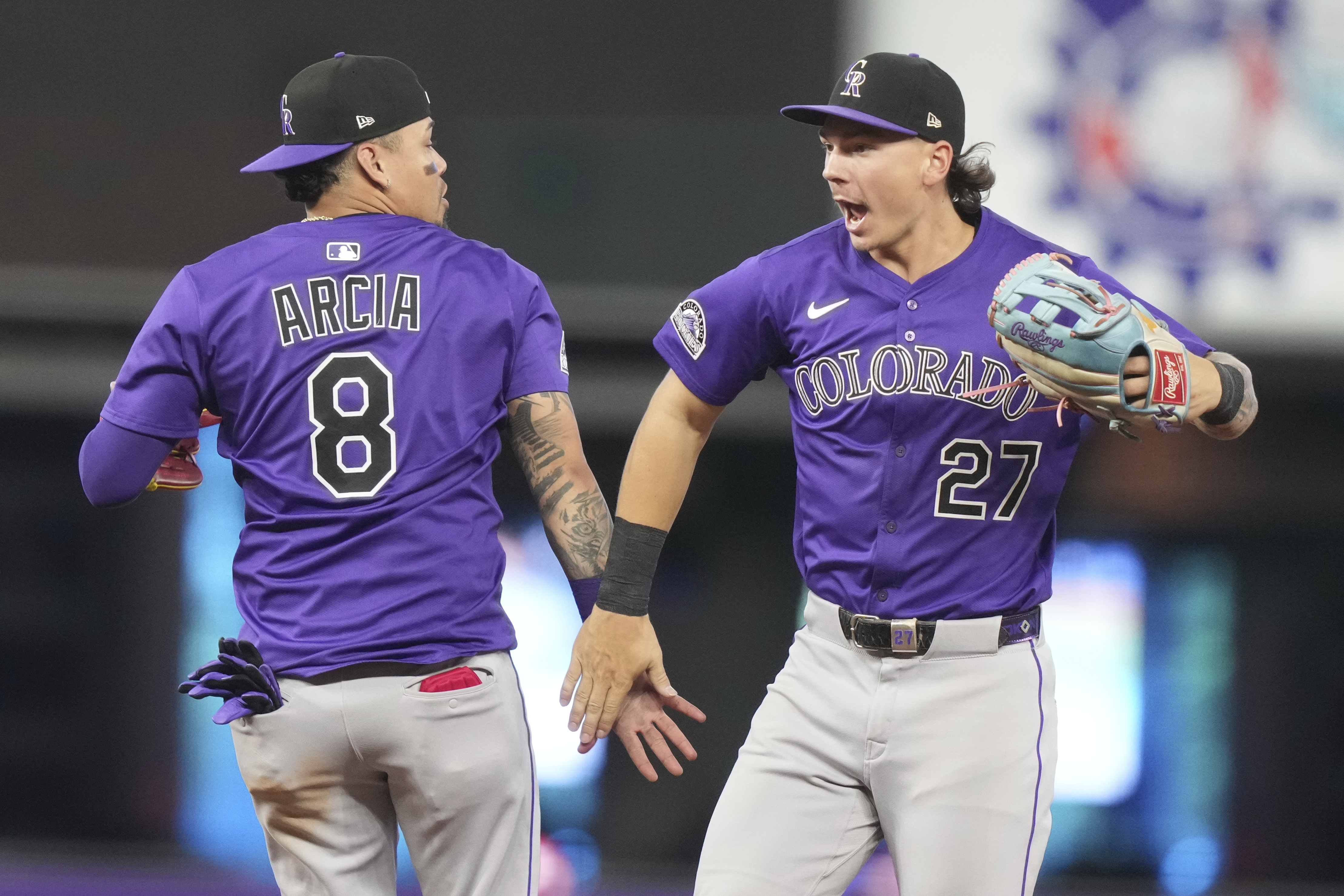 Colorado Rockies shortstop Orlando Arcia (8) and left fielder Jordan Beck (27) high-five after the Rockies defeated the Miami Marlins in a baseball game, Wednesday, June 4, 2025, in Miami.