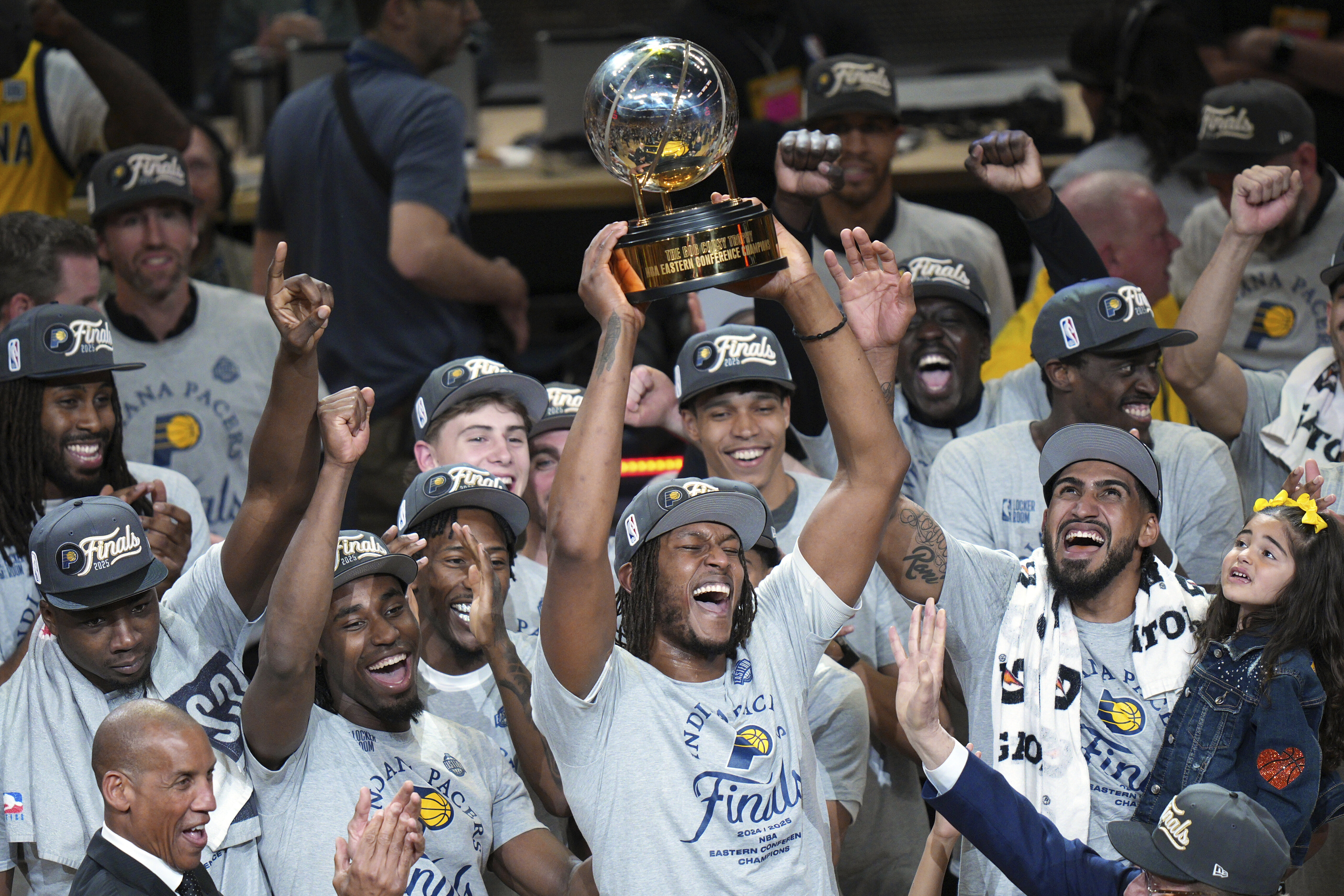 Indiana Pacers center Myles Turner holds the trophy as players celebrate after winning Game 6 of the Eastern Conference finals of the NBA basketball playoffs against the New York Knicks in Indianapolis, Saturday, May 31, 2025. 