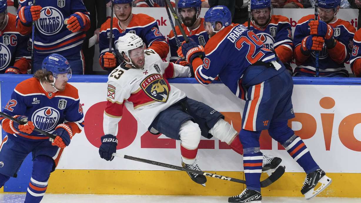 Edmonton Oilers' Leon Draisaitl (29) checks Florida Panthers' Carter Verhaeghe (23) during the second period in Game 1 of the NHL hockey Stanley Cup final series in Edmonton, Alberta, Wednesday, June 4, 2025.