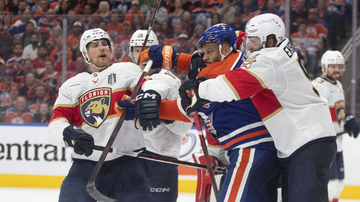 Florida Panthers' Aaron Ekblad (right) and Edmonton Oilers' Evander Kane (91) rough it up as Sam Reinhart (13) looks on during the first overtime period in Game 1 of the NHL Stanley Cup final in Edmonton, Alberta, Wednesday, June 4, 2025. /The Canadian Press via AP)