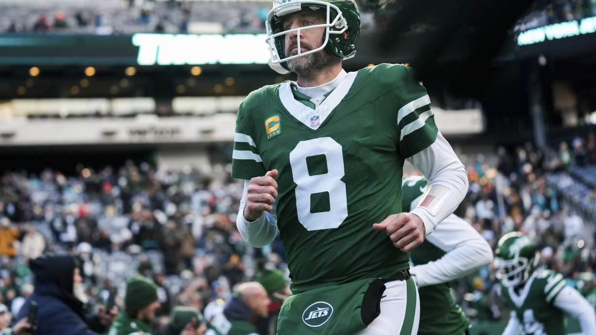 FILE - New York Jets quarterback Aaron Rodgers runs onto the field before an NFL football game against the Miami Dolphins, Sunday, Jan. 5, 2025, in East Rutherford, N.J.