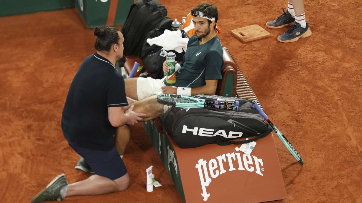Italy's Lorenzo Musetti receives medical assistance during a break at the semifinal match of the French Tennis Open against Spain's Carlos Alcaraz at the Roland-Garros stadium in Paris, Friday, June 6, 2025.