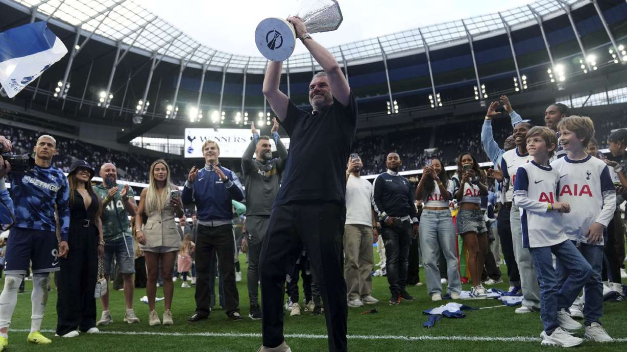 Tottenham Hotspur manager Ange Postecoglou holds up the Europa League trophy on the pitch during the English Premier League soccer match between Tottenham Hotspur and Brighton and Hove Albion at the Tottenham Hotspur Stadium, London. Picture date: Sunday May 25, 2025.