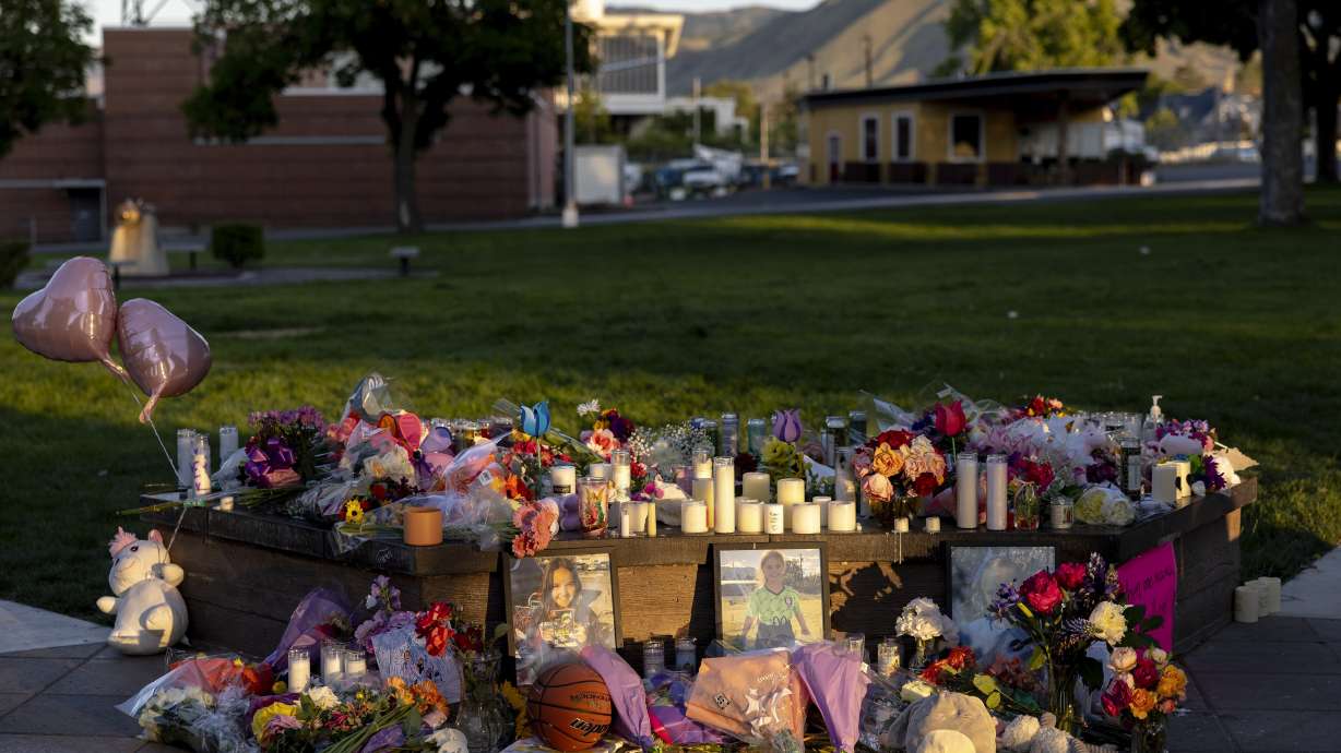 Pictures, flowers and candles mark a makeshift memorial Tuesday, in Wenatchee, Wash., in honor of Olivia, Paityn and Evelyn Decker, who were found dead near Leavenworth after their father Travis Decker failed to return them after a scheduled visitation.
