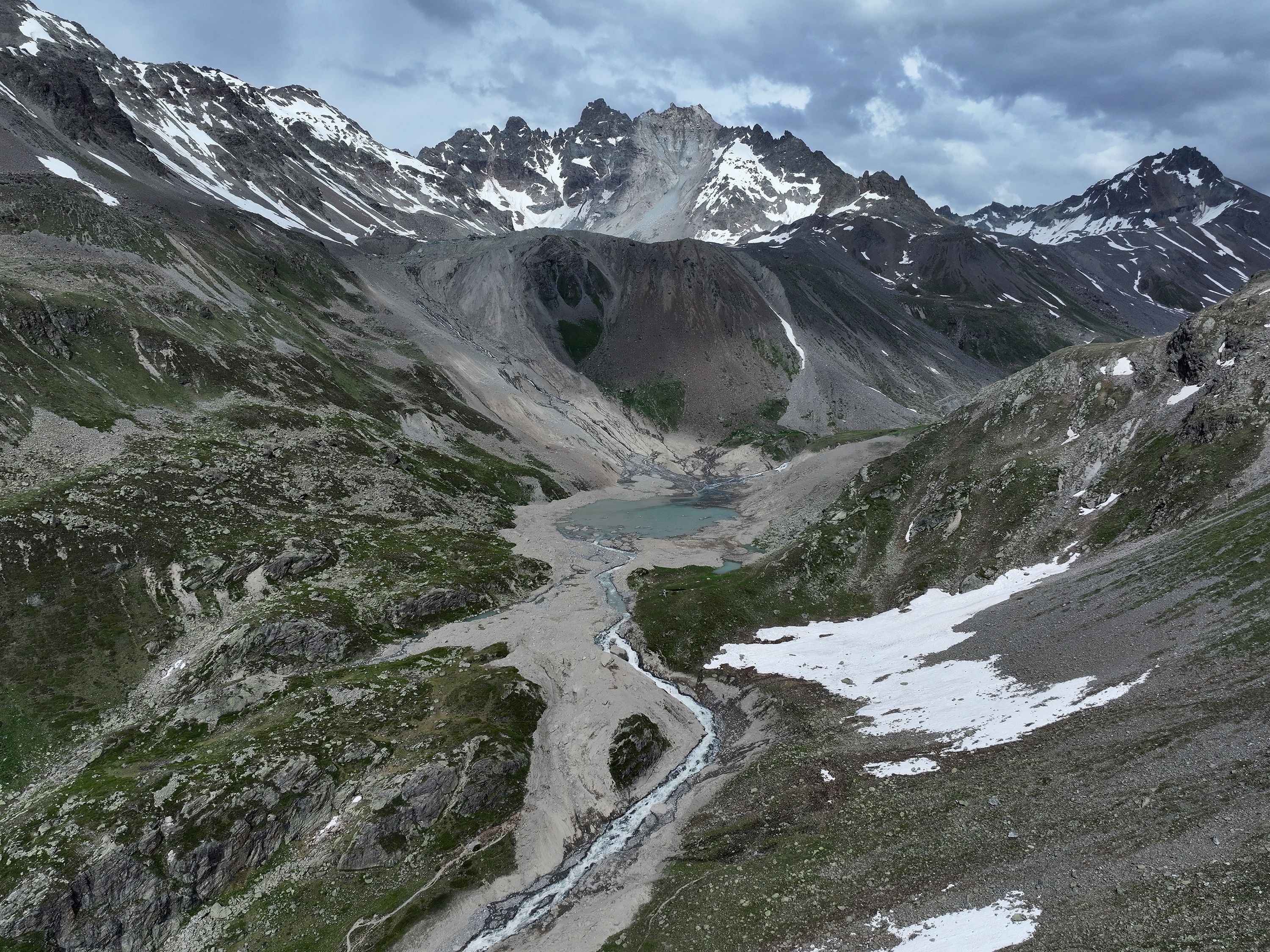 Partially collapsed Fluchthorn mountain stands above a swath of rock and gravel deposited by its rockslide into the valley below on June 22, 2023 near Galtur, Austria.